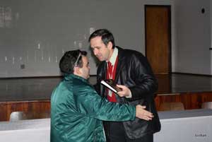 Alex Garcia abraça Marcos Henkes do Senai. Marcos tem um livro nas mãos.