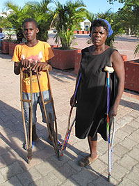Haitian boy gives new aluminum crutches to Haitian amputee