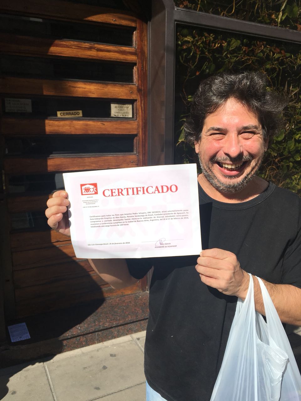 Imagem de um homem sorrindo exibindo um certificado